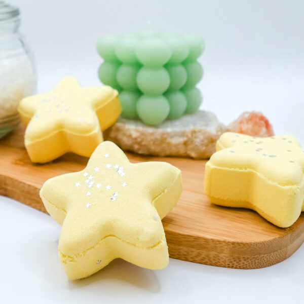 yellow star-shaped bath bombs on a wood wash board