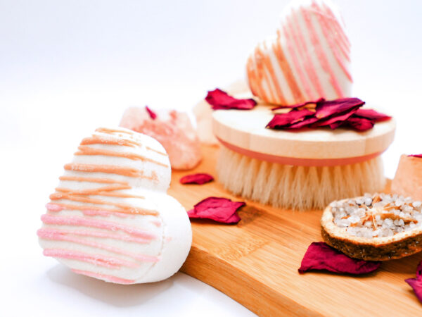 heart-shaped tangerine, coconut, and magnolia-scented bath bomb next to a wood board