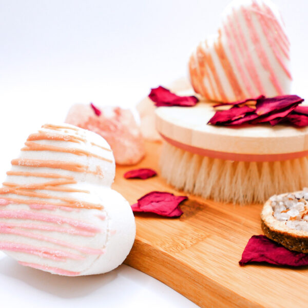 heart-shaped tangerine, coconut, and magnolia-scented bath bomb next to a wood board